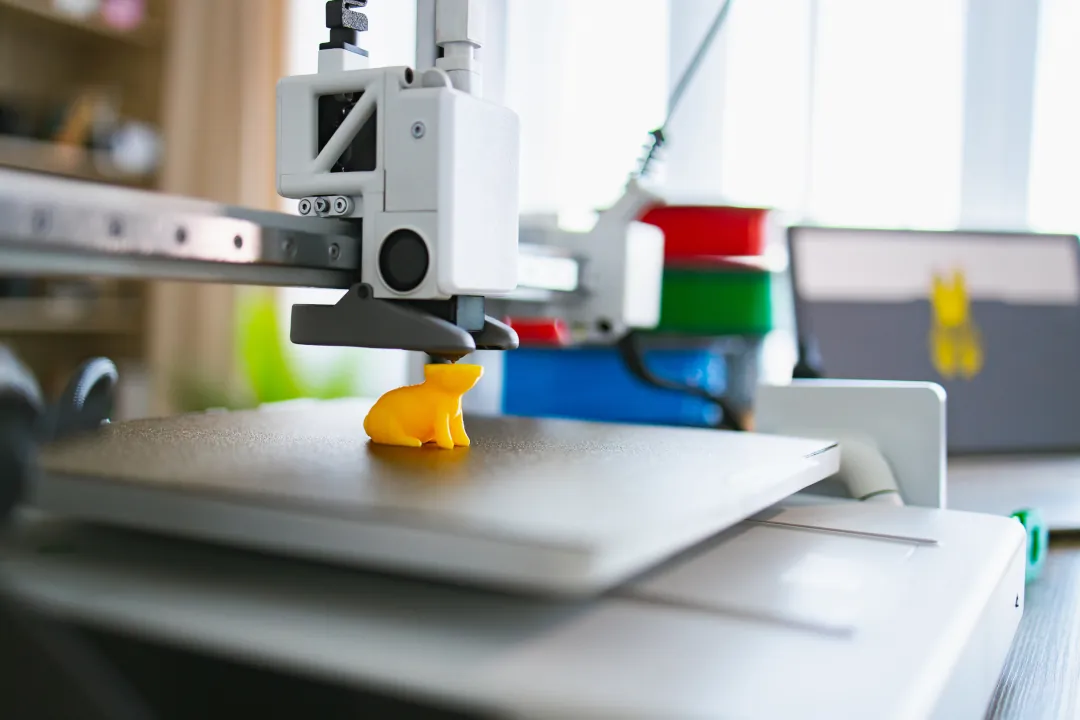 Impressora 3D imprimindo coelho amarelo